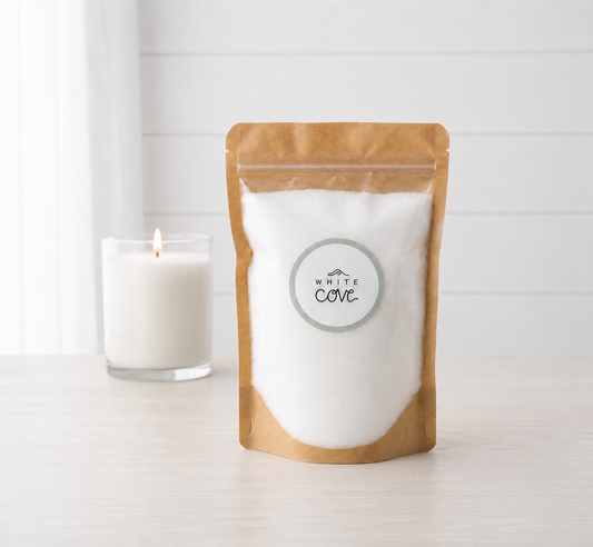 White Cove refillable candle sand bag, 400g of white pearled vegetable wax, beside a lit candle