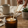 A luxury gold candle wick cutter and premium wooden wicks by White Cove UK. Styled with small dried botanicals in warm, natural light for a calm, minimal candle-making aesthetic