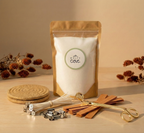 A complete, luxury refillable candle kit by White Cove UK. The sustainable set features a standing pouch of unscented plant-based candle sand, rustic coasters, premium wooden wicks, and a gold wick trimmer, styled in a minimal, warm setting