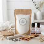 Sustainable sleep wellness bundle featuring White Cove UK's refillable candle sand. This lifestyle shot showcases the complete plant-based candle ecosystem alongside relaxing evening fragrance oils and luxury gold accessories, set in a calming, white bedroom aesthetic