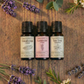 Premium wellness essential oil bundle by White Cove UK. Three amber glass bottles of Nikura pure essential oils surrounded by fresh botanicals, designed for scenting sustainable vegetable-based wax granules hand-packed in Dorset