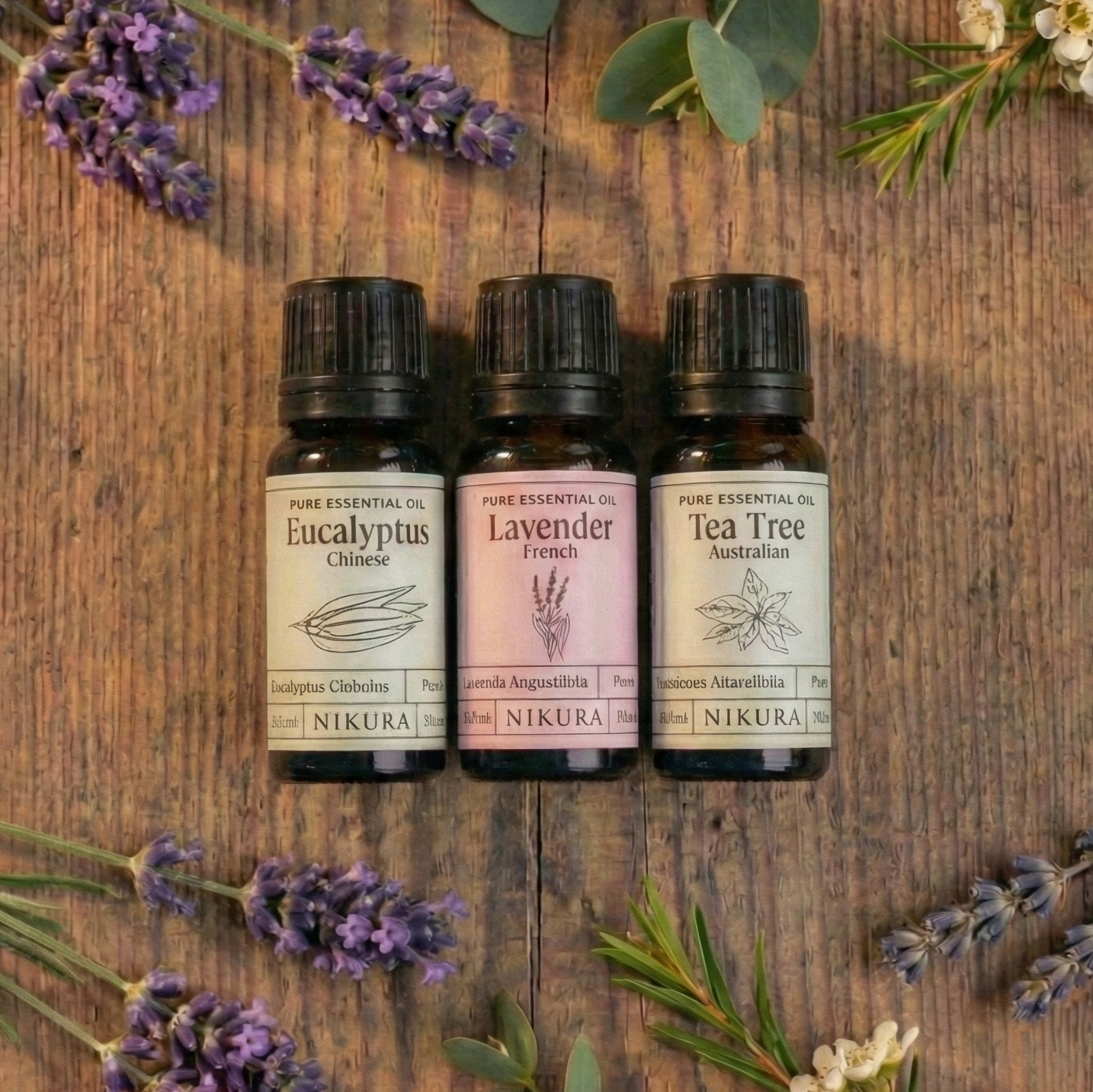 Premium wellness essential oil bundle by White Cove UK. Three amber glass bottles of Nikura pure essential oils surrounded by fresh botanicals, designed for scenting sustainable vegetable-based wax granules hand-packed in Dorset