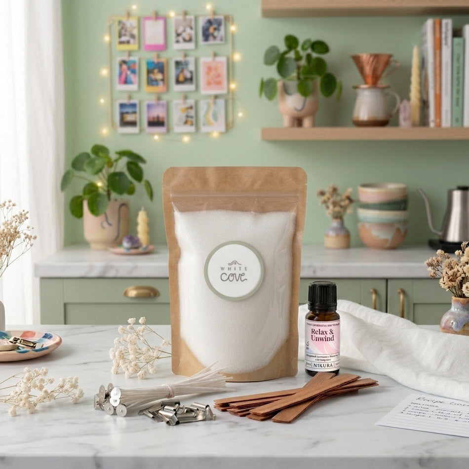 Sustainable candle making kit by White Cove UK styled in an aesthetic modern kitchen. This lifestyle shot showcases the complete plant-based candle sand ecosystem, including dual wick options and Relax & Unwind fragrance oil, arranged on marble with fresh botanicals and cozy room accessories