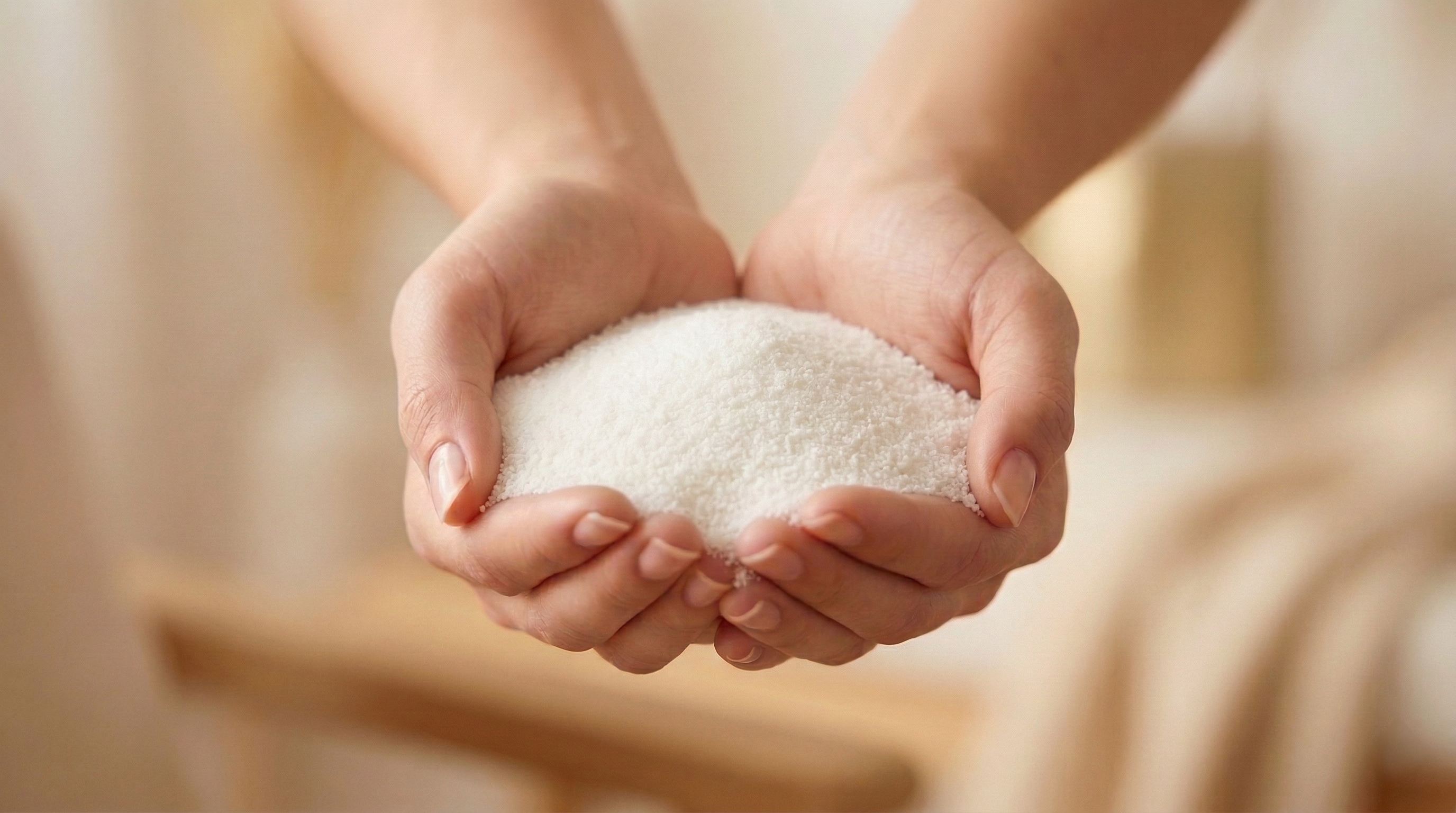 Close-up of pure vegetable-wax candle sand held in hands. A sustainable and paraffin-free candle alternative by White Cove UK, hand-packed in Dorset